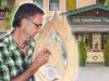 Martin Seer beim Holzschnitzen vor seiner Holzschnitzerei in Wagrain